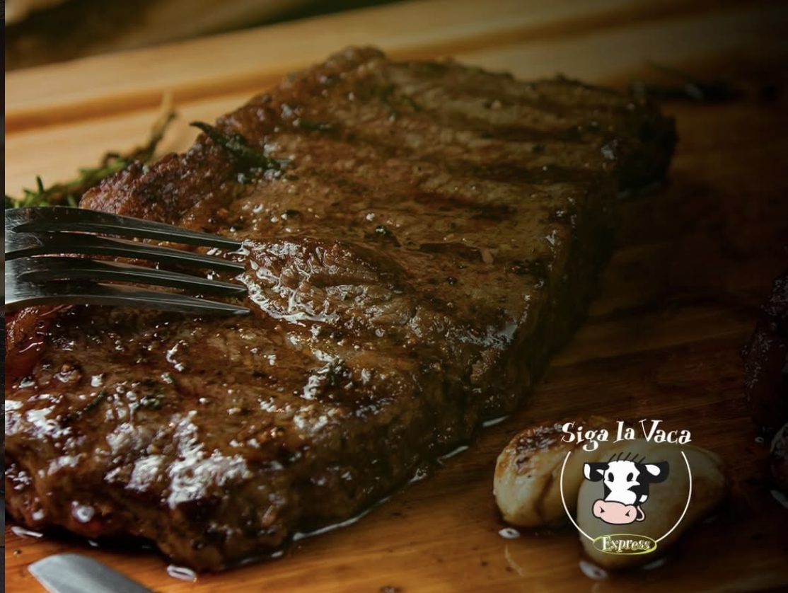 Bife a la parrilla sobre tabla de madera